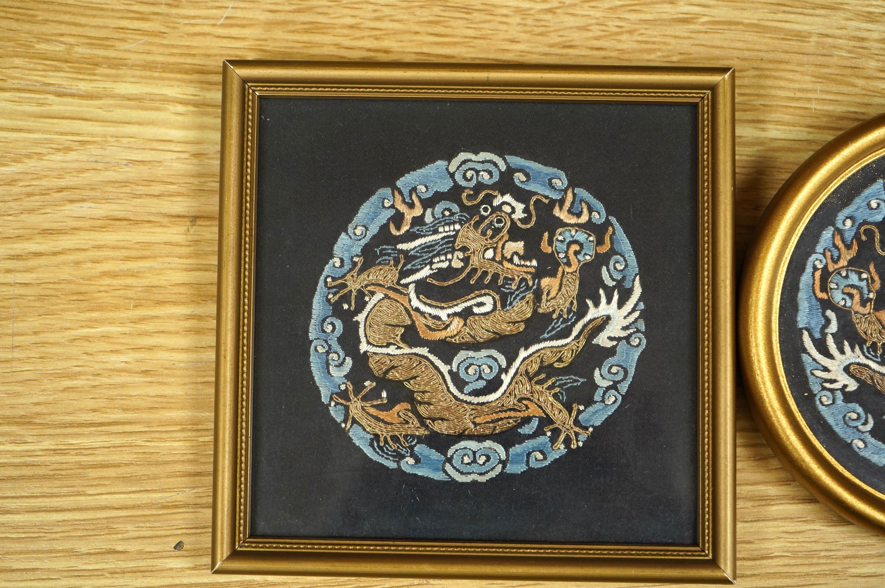 Three Chinese early 20th century embroidered roundels of five claw dragons, embroidered in gold thread and blue silk thread possibly symbolic motifs cut from a robe, embroidery 9cm diameter. Condition - embroidery good,